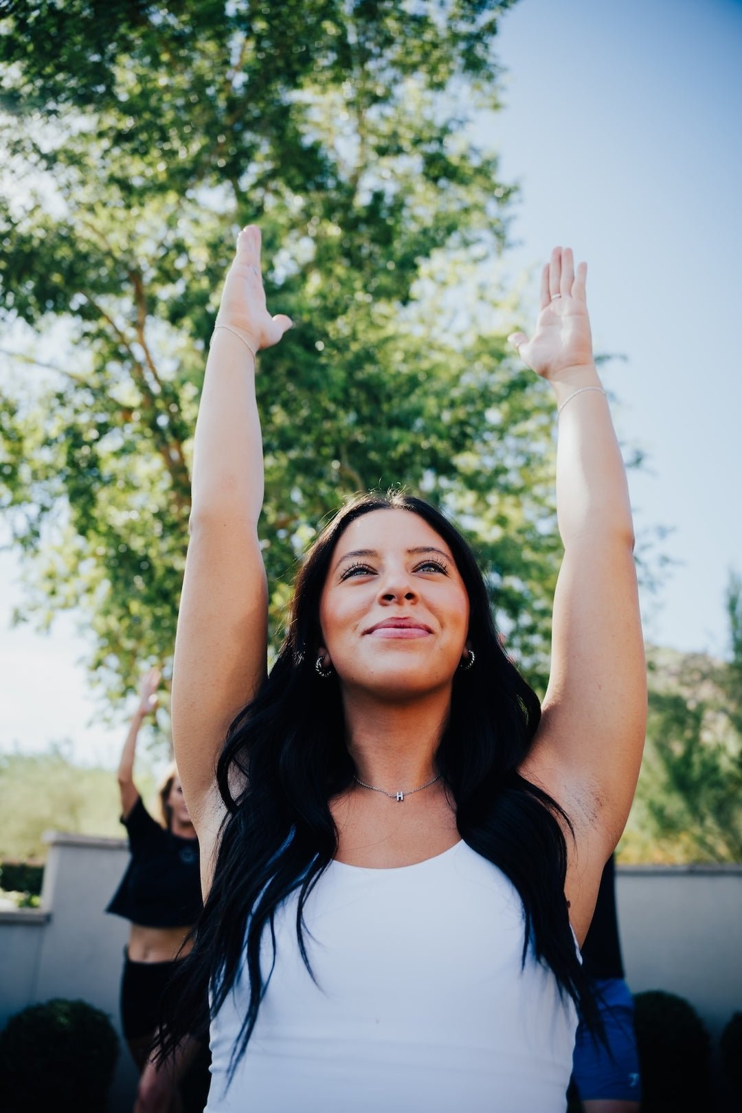 Arms stretched skyward during an outdoor group class